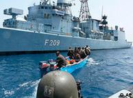 Several alleged pirates in a boat approach a German warship