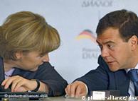 German Chancellor Angela Merkel leans in to listen to Russian President Dmitry Medvedev