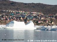 The town of Illulissat in the distance behind an ice berg