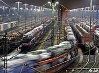 Trains loaded with cars pass through a freight yard