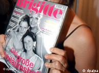 Woman holding up copy of Brigitte magazine