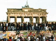 Berlin wall on Nov 10, 1989, with people climbing over it