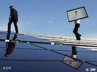 Two men install solar panels on a rooftop