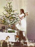 Als ein Engel verkleidetes Mädchen schmückt einen Weihnachtsbaum (Foto: dpa)