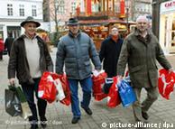 Three men carrying plastic shopping bags
