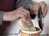 A hand putting money into a kitchen container