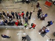 Para penumpang menunggu pemeriksaan di sebuah bandara