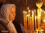 Orthodox woman praying with candles