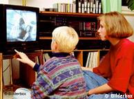 Child watches television with his mother