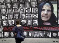 A boy pauses in front of a wall-sized poster depicting the faces of 90 survivors of the mass killings of Armenians in the Ottoman Empire
