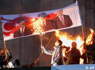 Armenians burn a poster with images of Turkish leaders during a rally in Yerevan, Armenia, Friday April 23, 2010, to commemorate the 95th anniversary of killings of Armenians by Ottoman Turks