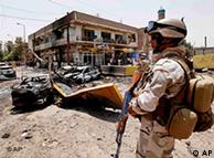 An Iraqi Army soldier stands guard at the site of a car bomb attack in Baghdad, Iraq