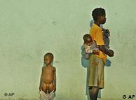 Mãe com crianças em frente a um hospital,  no Kuito, à espera de comida