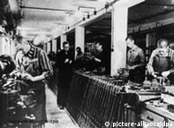 Prisioneiros do campo de concentração de Dachau trabalham na produção de armas