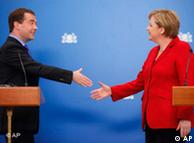 Russian President Dmitry Medvedev, left, and German Chancellor Angela Merkel shake hands during a press conference
