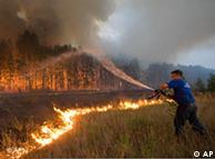 A fire fighter attempts to extinguish a forest fire 