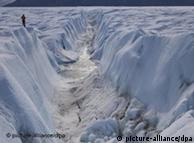 A glacier traveller looks down into one of the 'cracks' in the Petermann glacier 