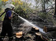 A firefighter spraying water in a forest
