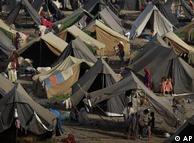 People walk around tents at a camp for Pakistani families displaced by floods 