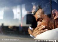 An ethnic Roma man looks down while seating inside the transfer bus shortly after arriving at the international airport of Timisoara city