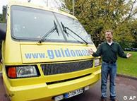 Guido Westerwelle stands next to the Guidomobile, a yellow minivan used as a promotional stunt during the 2002 elections
