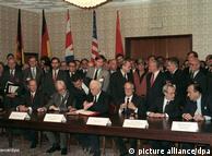 Foreign ministers at a table signing the agreement