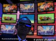 A man surrounded by TVs has on a pair of 3-D glasses