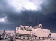 Tropas americanas no Kuwait em 24/02/91, com fumaça de poços em chama ao fundo