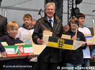 Bremen Premier Jens Boehrnsen surrounded by students during reunification celebrations