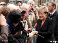 Kanselir Angela Merkel berjabat tangan dengan warga yang hadir dalam perayaan di Bremen (03/10).