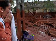 A Hungarian woman reacts while seeing her home flooded by toxic mud