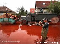 A man wades through chemical sludge in a village in western Hungary