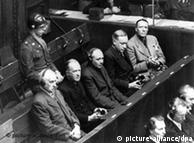 Some of the accused at the Nuremberg Trials on December 6, 1945 - from left to right: Karl Doenitz, Hermann Goering and Rudolf Hess - watched over by two American soldiers