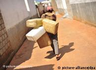 A woman carries empty containers for water
