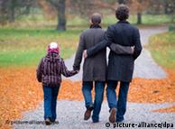 Родина - два чоловіки і хлопчик - на прогулянці у парку