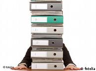A person behind a stack of folders