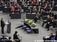 Der niederländische Holocaust-Überlebende und Vertreter der Sinti, Zoni Weisz (l), spricht am Donnerstag (27.01.2011) während einer Gedenkveranstaltung für die Opfer des Nationalsozialismus im Plenarsaal des Bundestages in Berlin. In der ersten Reihe vor dem Plenum haben Bundesratspräsidentin Hannelore Kraft (SPD), Bundestagspräsident Norbert Lammert (CDU), Bundeskanzlerin Angela Merkel (CDU) und der Präsident des Bundesverfassungsgerichtes, Andreas Voßkuhle, Platz genommen. Eingeladen waren neben Bundestagsabgeordneten und Vertretern der Verfassungsorgane auch junge Menschen aus Polen, Frankreich und anderen Ländern. Foto: Soeren Stache dpa/lbn
