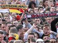Jovem exibe uma faixa com dizeres extremistas em meio a torcedores da seleção alemã