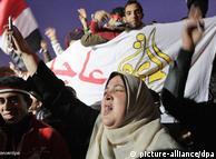 Egyptian protesters cheer, waving flags and banners