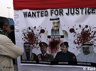 A Bahraini anti-government protester looks at a banner showing Bahraini prime minister Shiek Khalifa bin Salman Al Khalifa, top, and other Bahraini officials at the Pearl roundabout in Manama, Bahrain