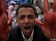 An anti-government protestor shouts with blood on his hands during clashes in Sanaa, Yemen