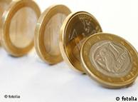 Euro coins standing on end, tipping toward each other