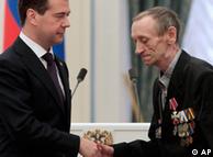 Russia's President Dmitry Medvedev poses with Vyacheslav Gryzunov, right, during a ceremony to award 'liquidators'