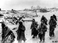German soldiers, their uniforms tattered from the battle, making their way in the bitter cold through the ruins of Stalingrad. 