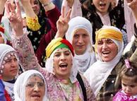 Kurdish women make V-victory signs as they chant slogans during a demonstration in Istanbul
