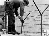 Soldado coloca arame farpado sobre o Muro