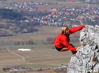 A rock climber hangs on a cliff in Germany