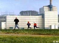 Un padre juega con sus hijos en las afueras de una planta nuclear.